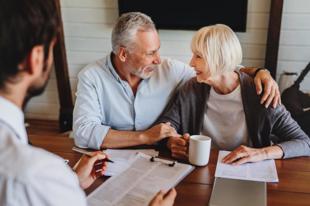 a senior couple meets with a realtor to discuss selling their home and moving into assisted living