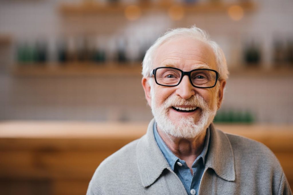an elderly man smiles big and thrives in independent or assisted living