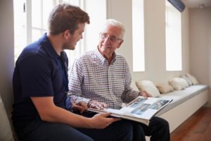 a young man visits his grandfather in his memory care program in assisted living