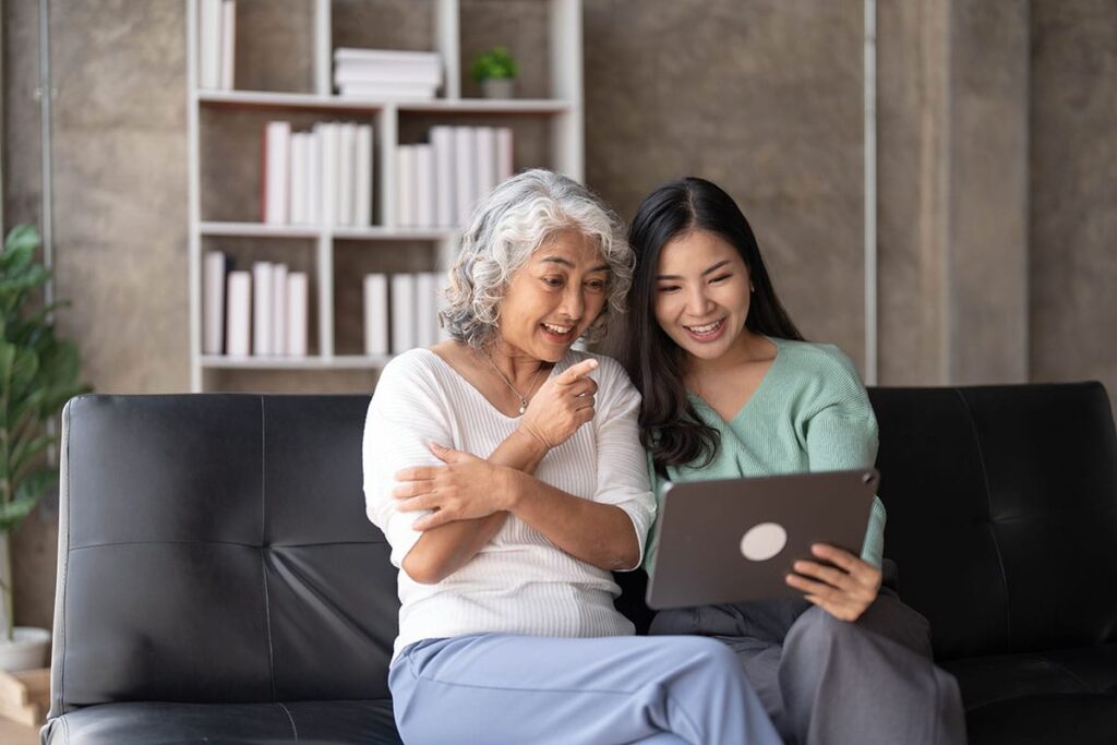 Woman sits on couch as she visits senior loved one in senior independent living
