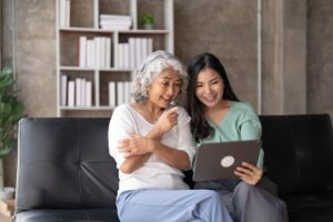 Woman sits on couch as she visits senior loved one in senior independent living