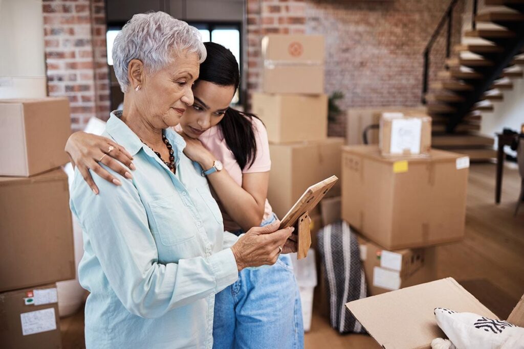 Woman hugs her senior mom as she helps her pack, wondering if her parent is in need of dementia care