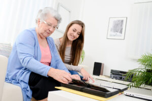 Woman helps senior grandma with task as she wonders, "how much is respite care in houston, tx?"