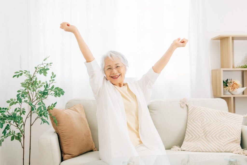 Woman stretches on couch as she enjoys daily life in a senior living community