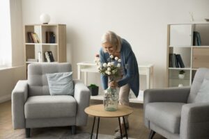 Senior puts flowers on table after learning how to personalize living space in a senior community